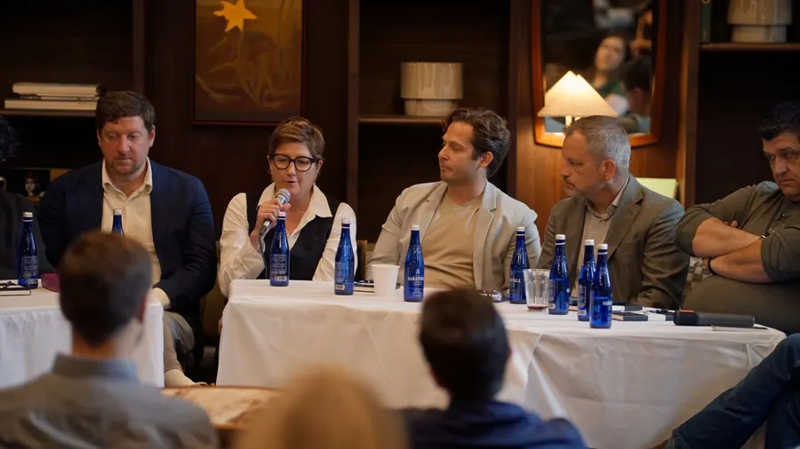 Four panelists at the left table listening to the conversation