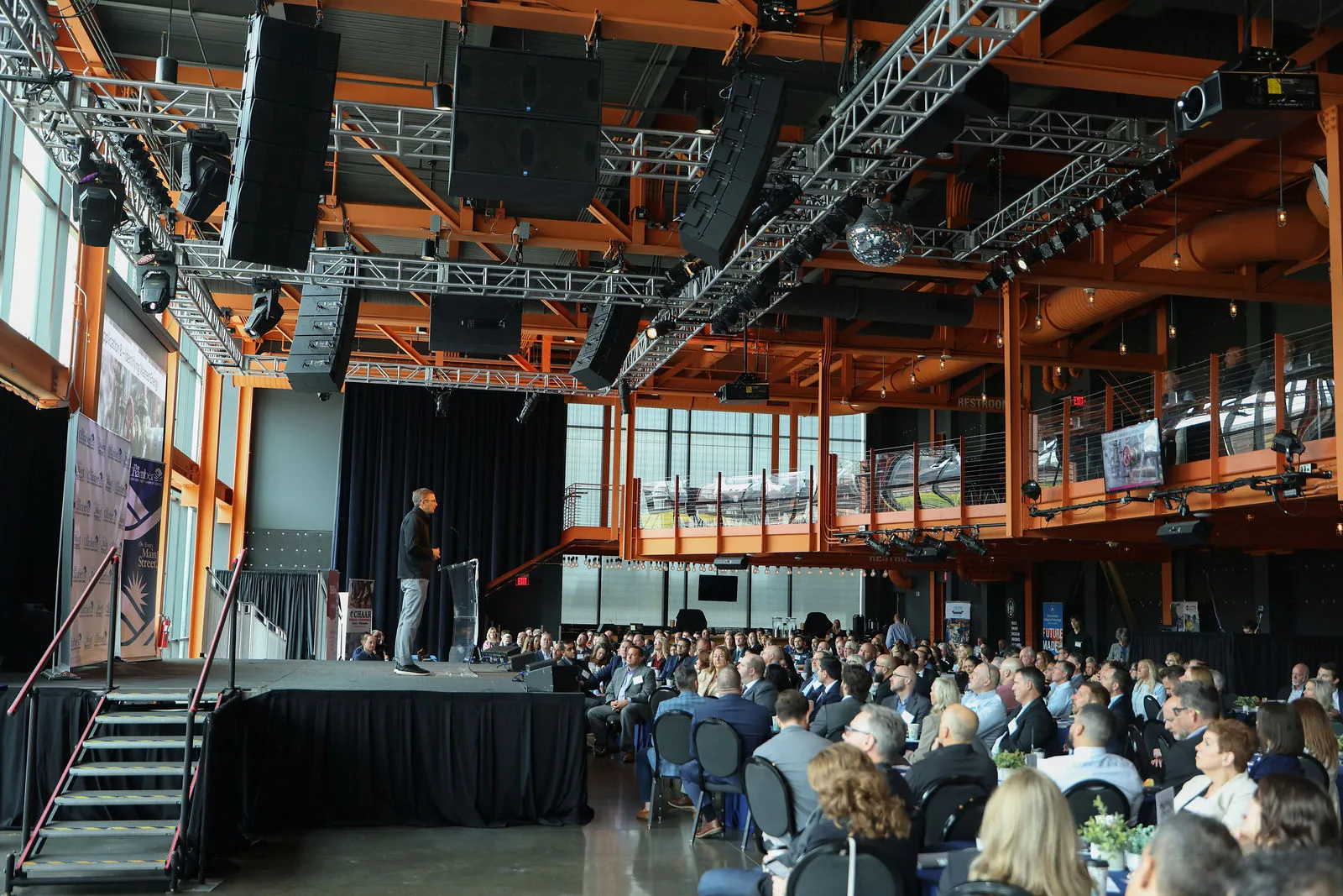 A full house at the Musikfest Café at SteelStacks during the 2026 Lehigh Valley Manufacturing Forum, speaker on stage under the orange steel trusses