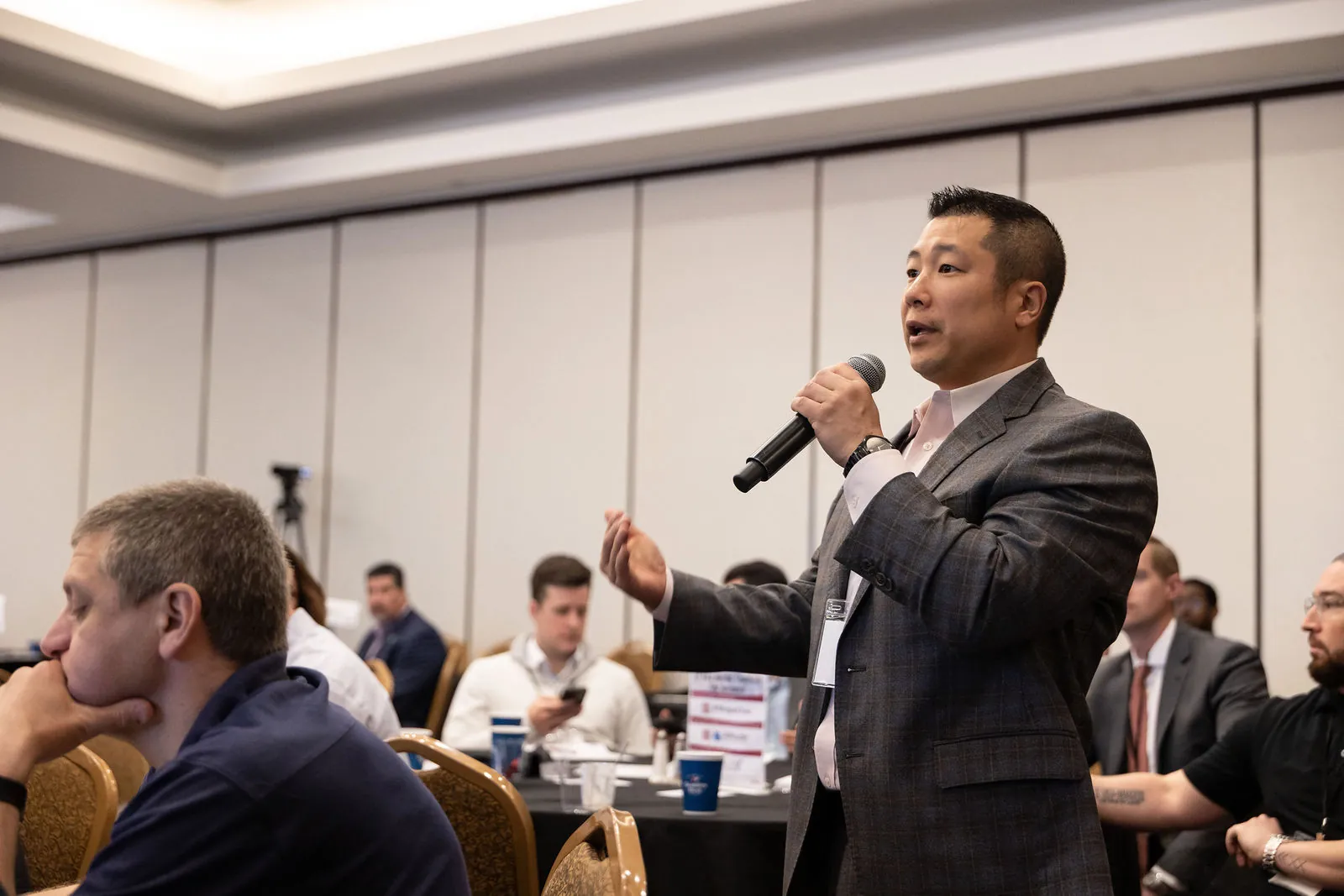 An attendee standing with a microphone to ask the panel a question