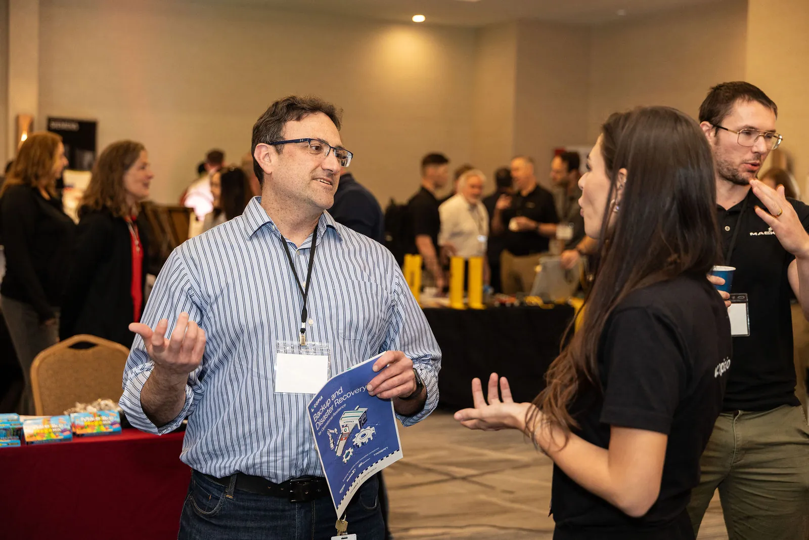 Attendees talking at a vendor table on the expo floor