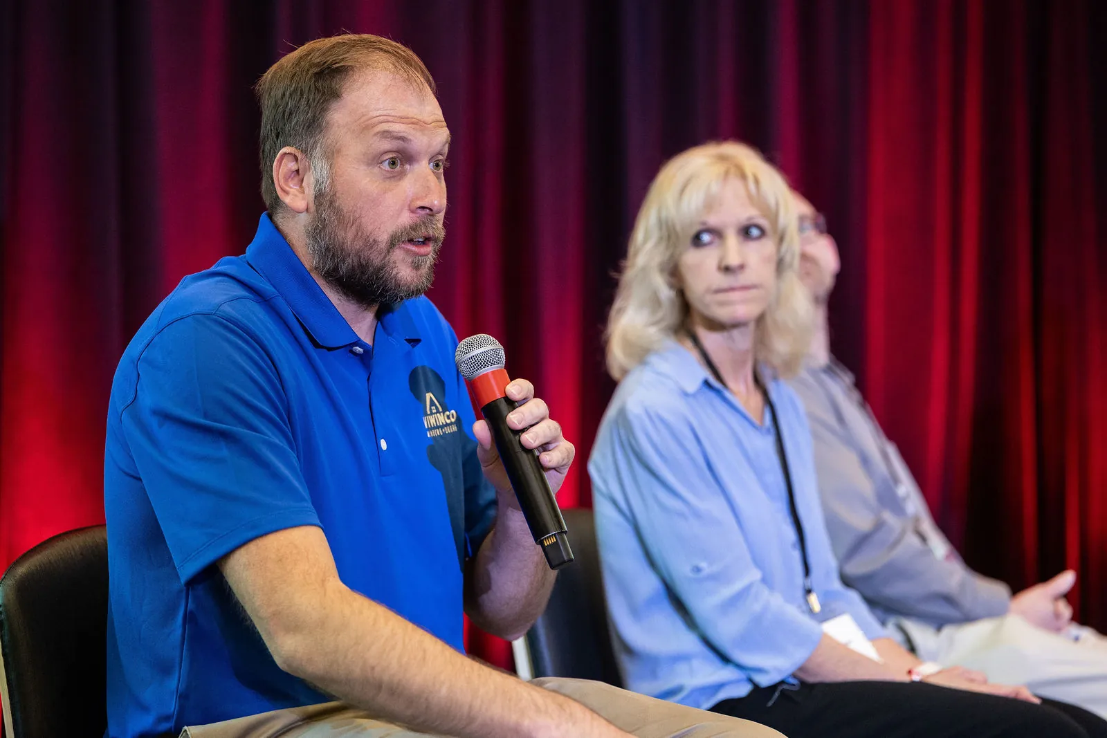 A panelist answering a question into a handheld microphone