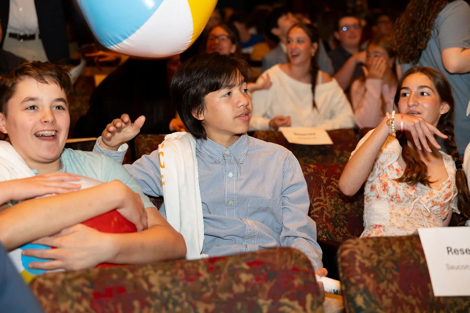 Students laughing in their seats with a beach ball overhead