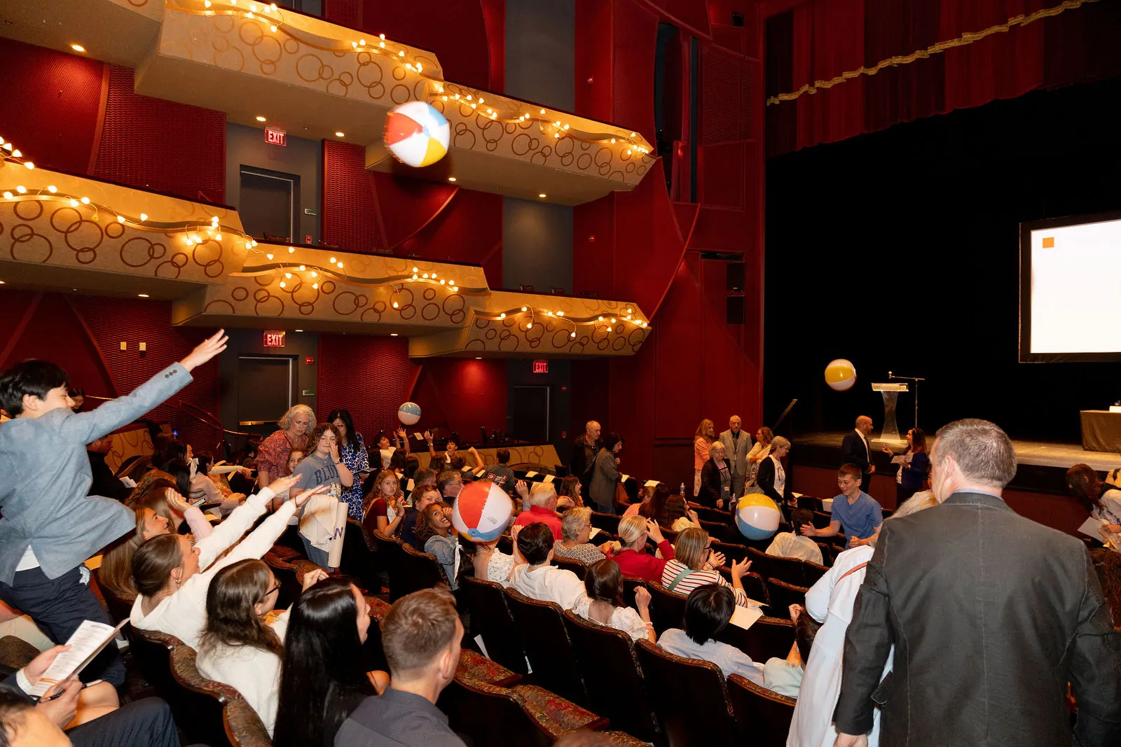 Beach balls flying over the crowd in the Whitaker Center theater, shot from the stage