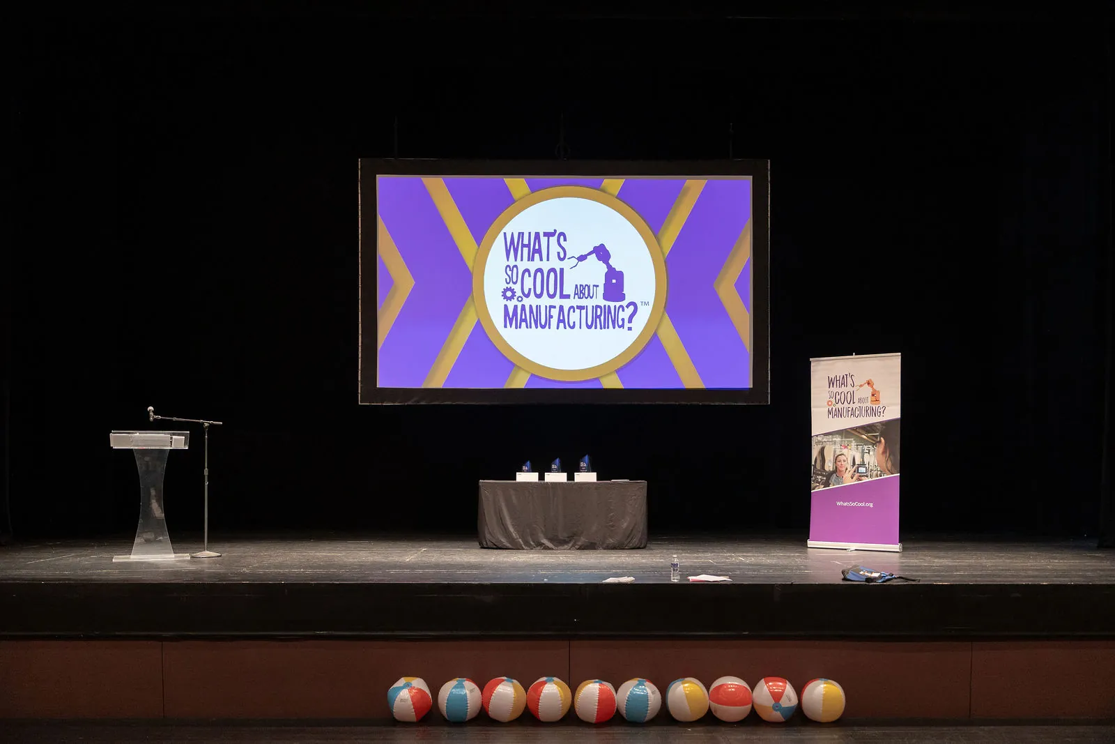 The stage set with the contest logo on screen and a row of beach balls along the front edge