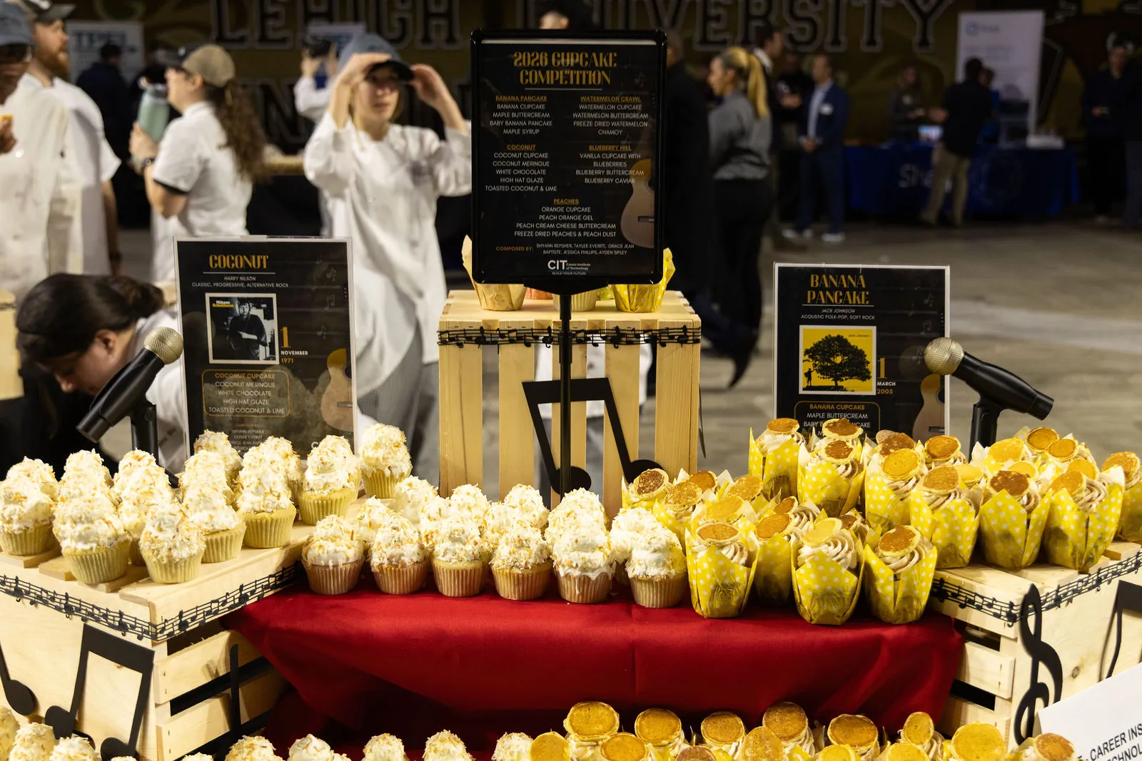 A culinary school table in the cupcake competition with rows of decorated cupcakes