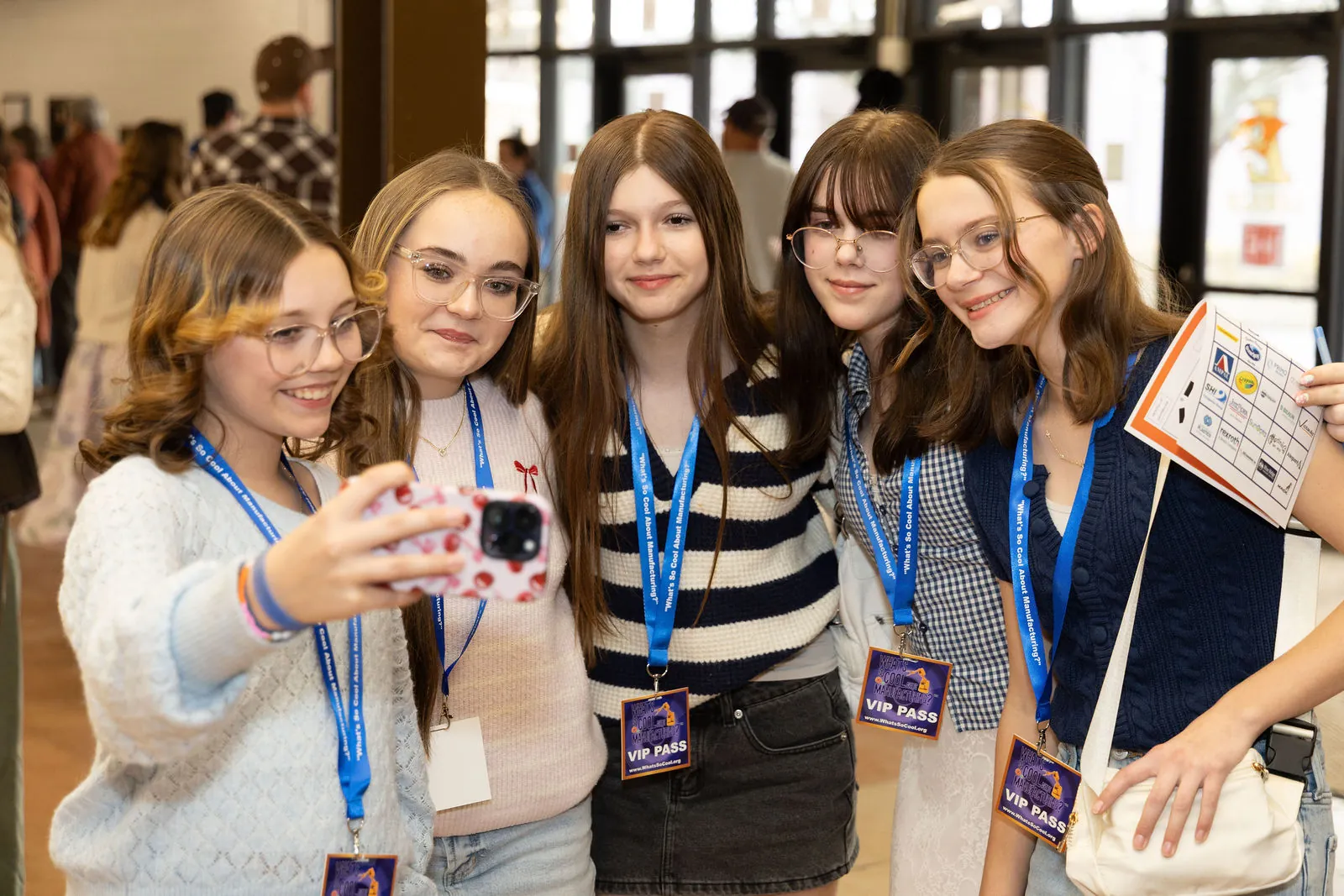 A group of students in VIP lanyards taking a selfie during the pre-show